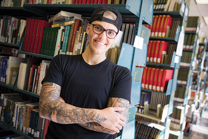 Sam Blanchard surrounded by books in a library.