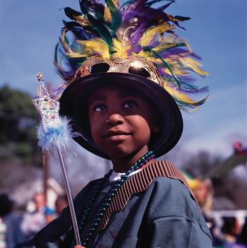 Student with a Mardi Grass' hat, bids and wand