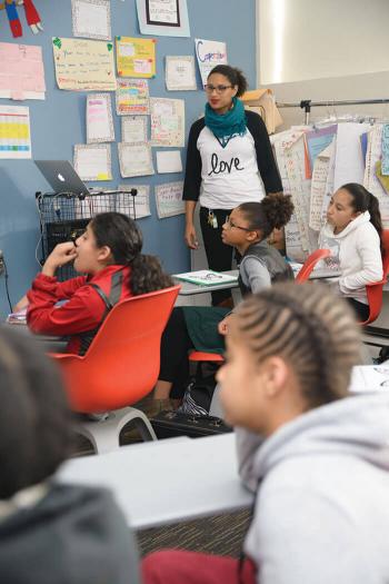 A teacher looks on during a class discussion.