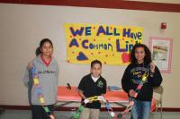 Students with a paper link chain in front the poster 'We ALL have a common link!'